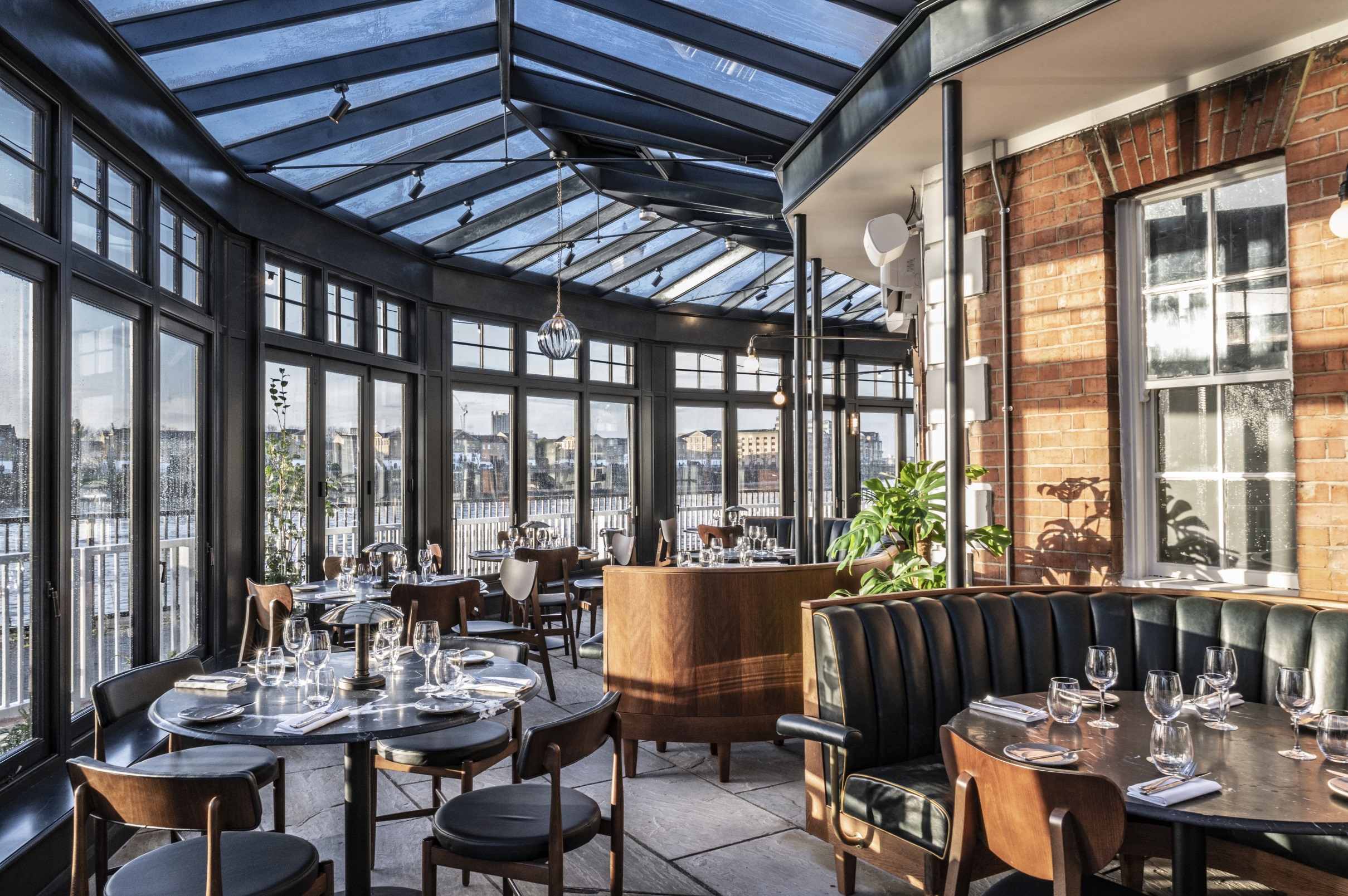 Stylish modern restaurant with large windows, perfect for corporate events and gatherings. - Banner