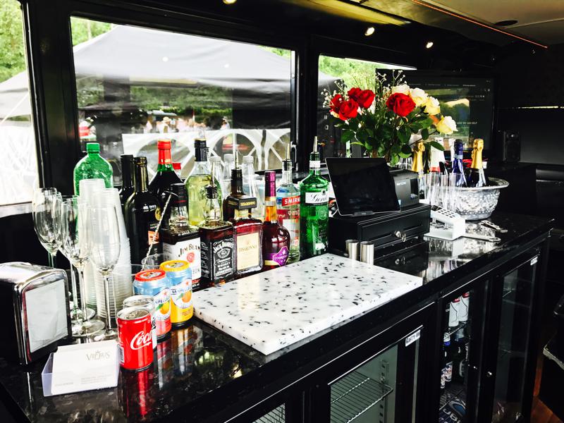 VIP bus bar with sleek black counter, elegant glassware for events and celebrations. - Banner