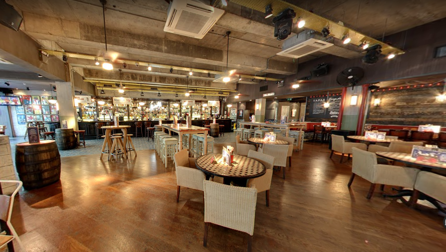 Full Venue Hire at Revolucion De Cuba Cardiff, modern industrial event space with warm lighting. - Banner