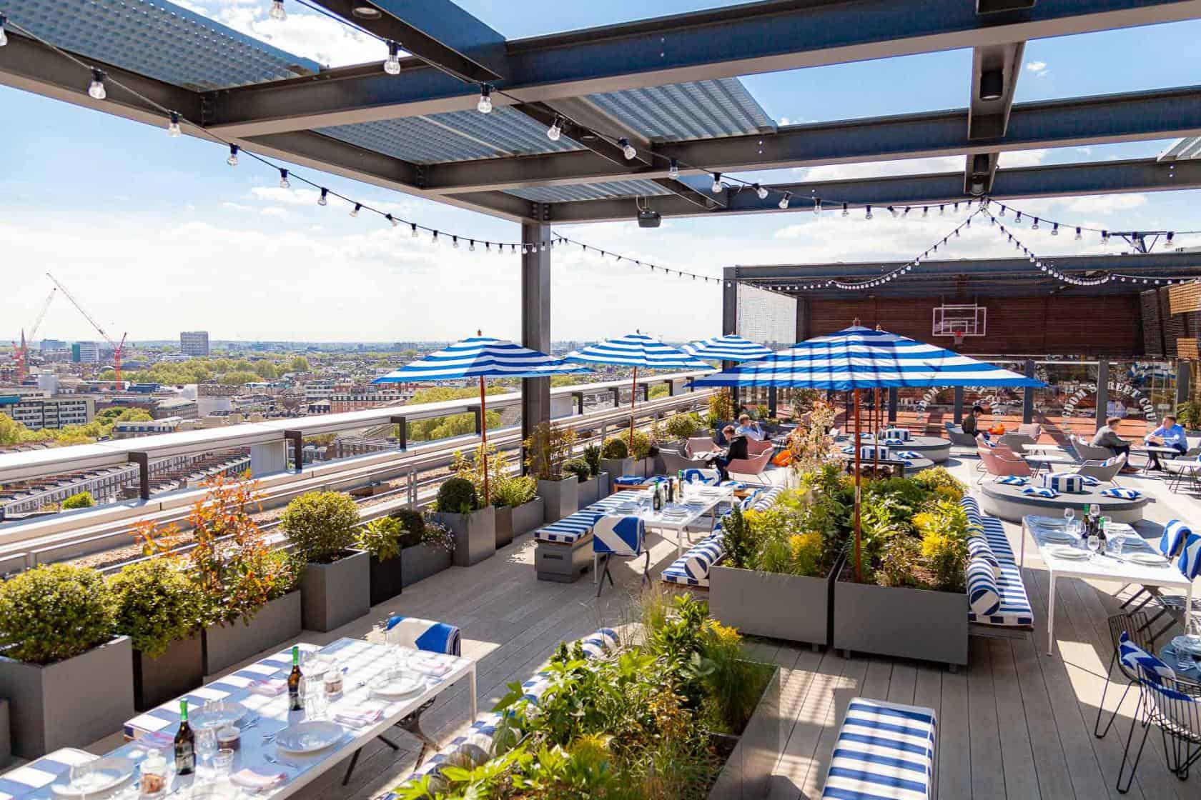 Skylark Rooftop Bar with blue umbrellas, perfect for events and gatherings. - Banner