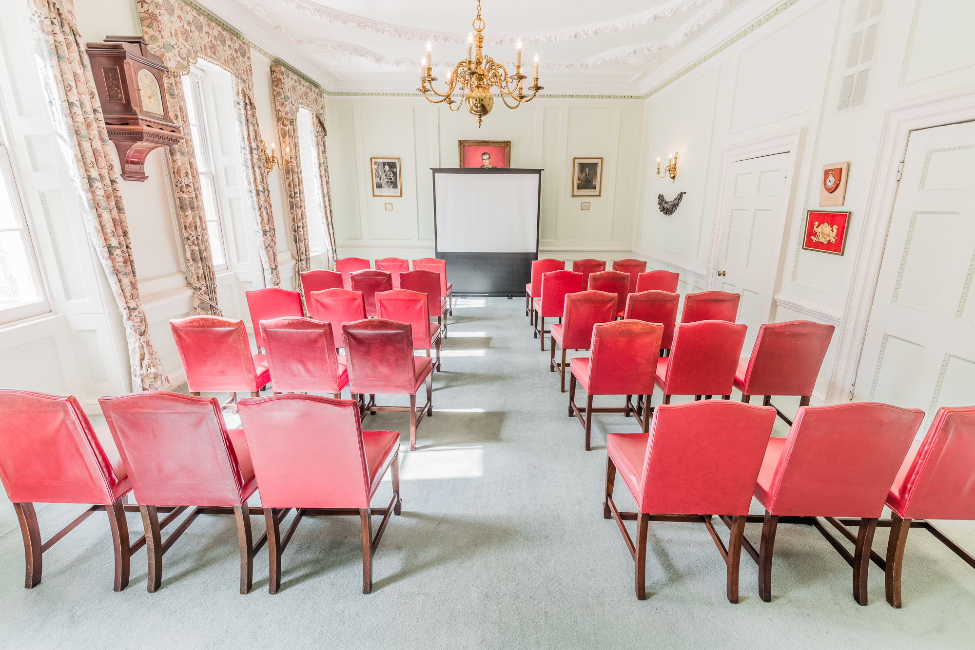 Meeting room at Coopers' Hall with red chairs for presentations and natural light.
