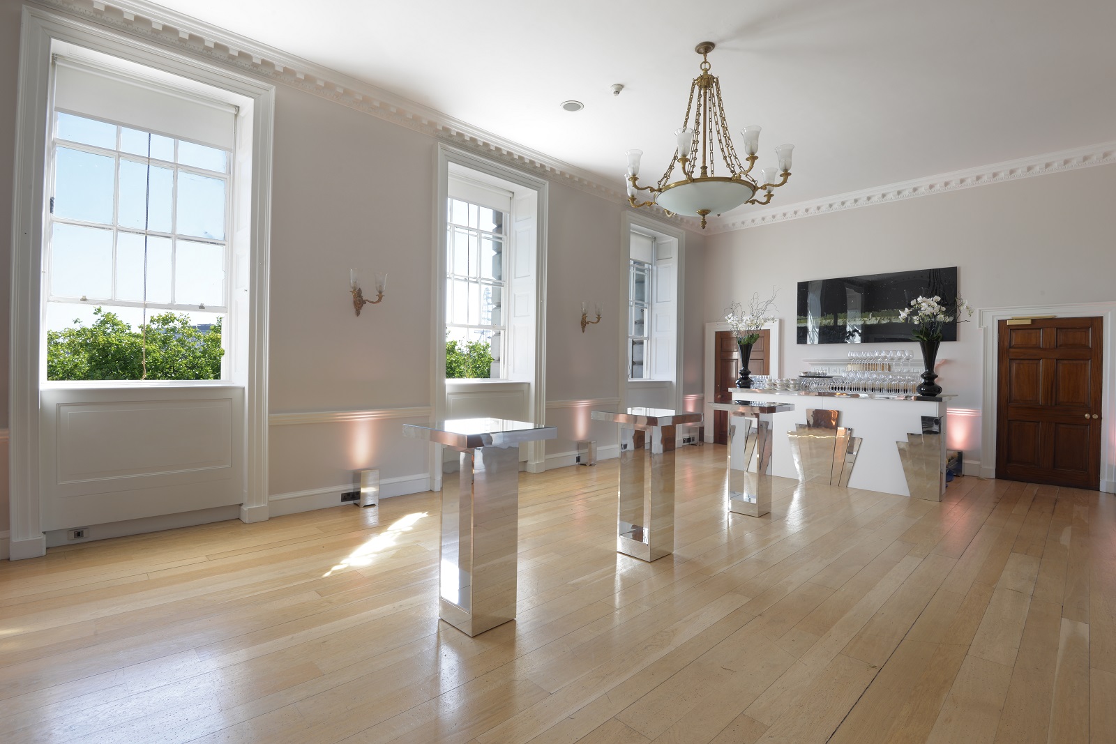 Elegant Navy Board Rooms at Somerset House, featuring large windows and chandelier for events.