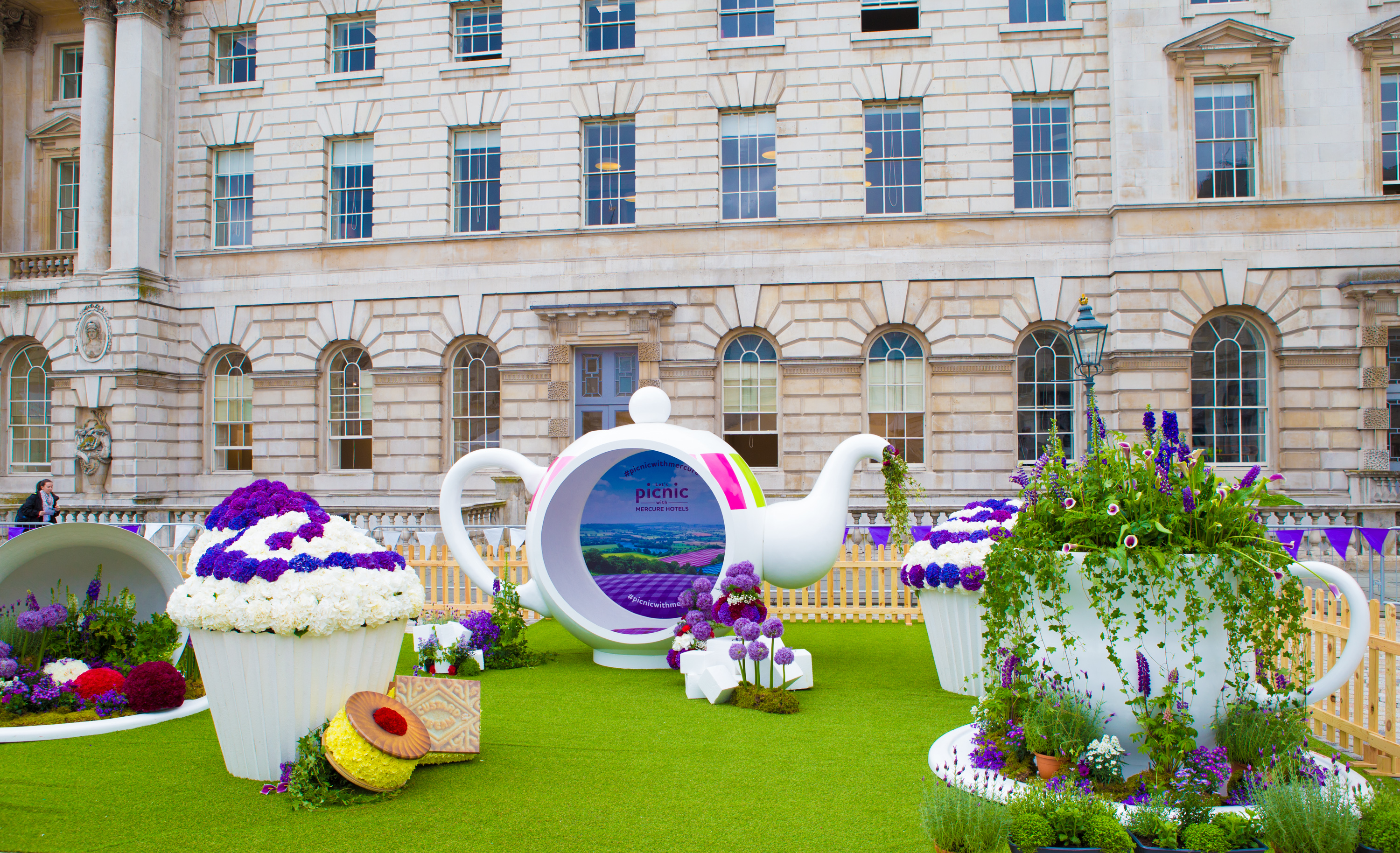Whimsical outdoor event at Edmond J. Safra Fountain Court with oversized teapots and flowers.