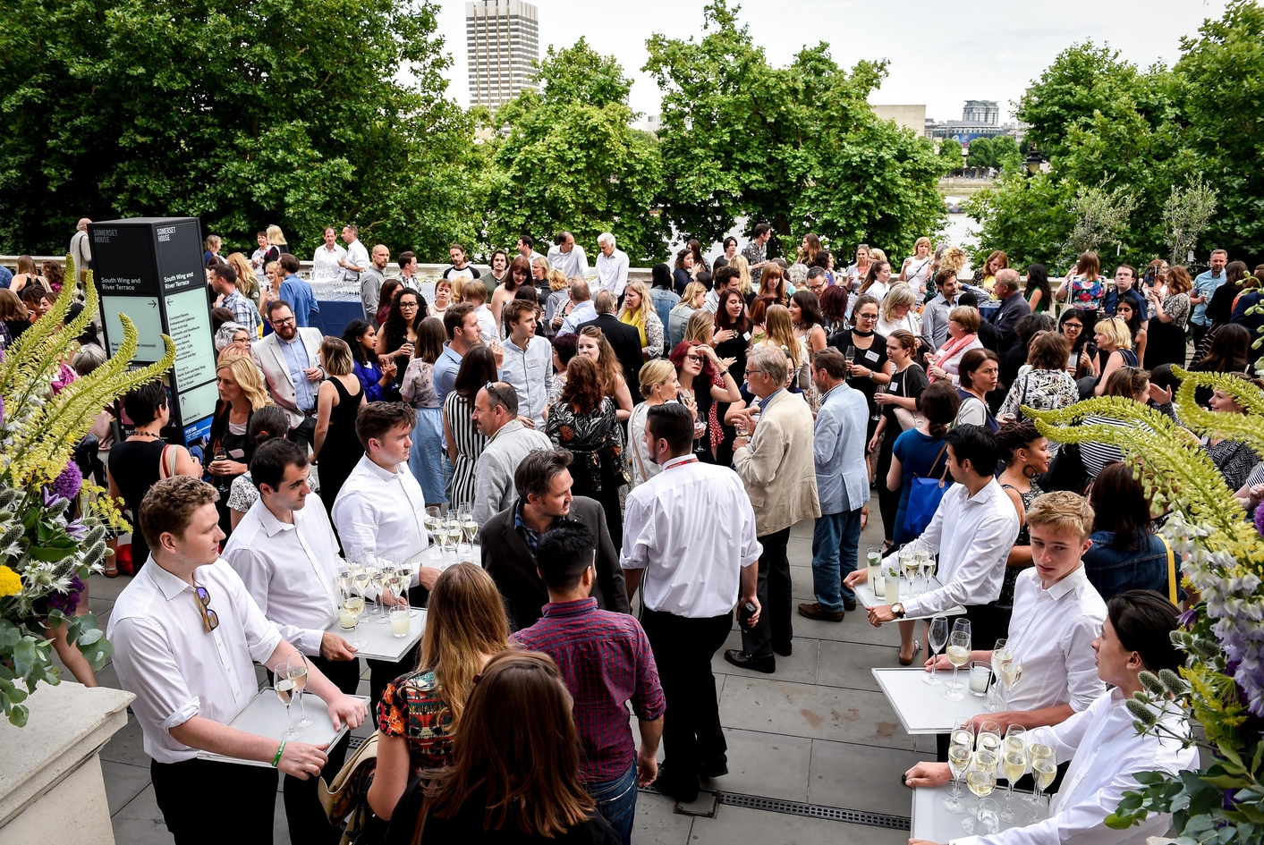 Vibrant outdoor event at The River Terrace, Somerset House with lush greenery and networking.