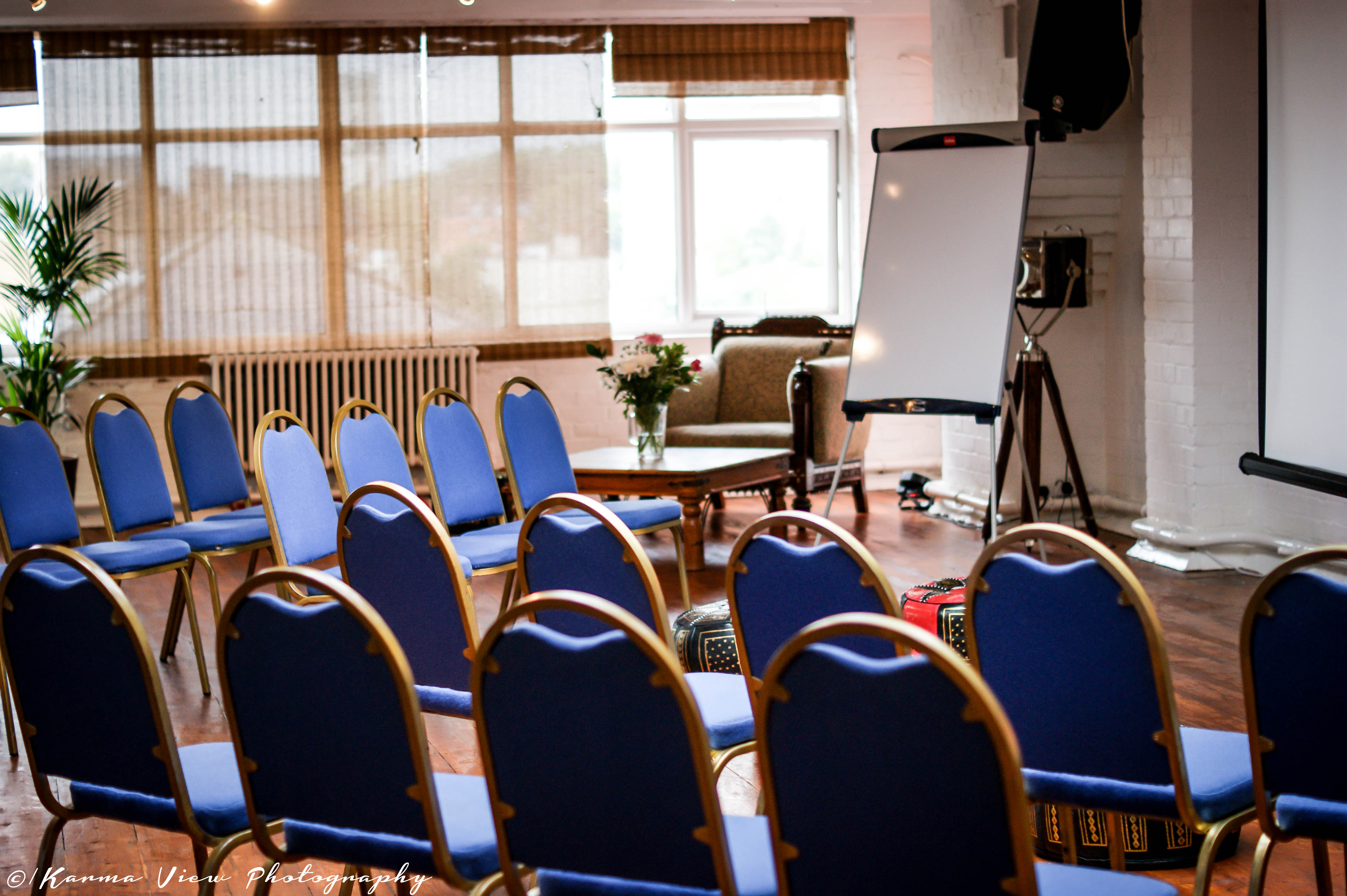 4th Floor Studios meeting space with blue chairs, ideal for workshops and presentations.