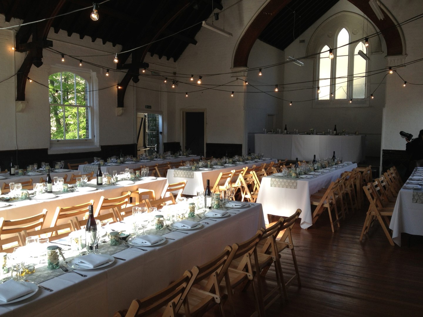 Elegant event space in Saint Barnabas Dalston with long dinner tables and warm lighting.