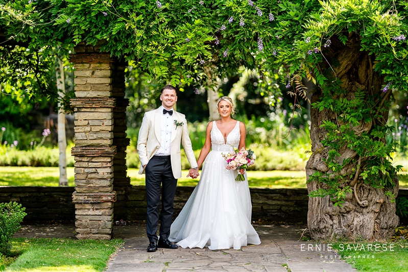 Outdoor wedding setup at Tudor Barn Eltham with lush greenery and floral accents.