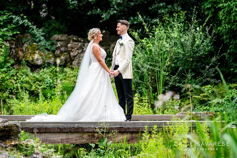 Intimate outdoor wedding at Tudor Barn Eltham with lush greenery backdrop.