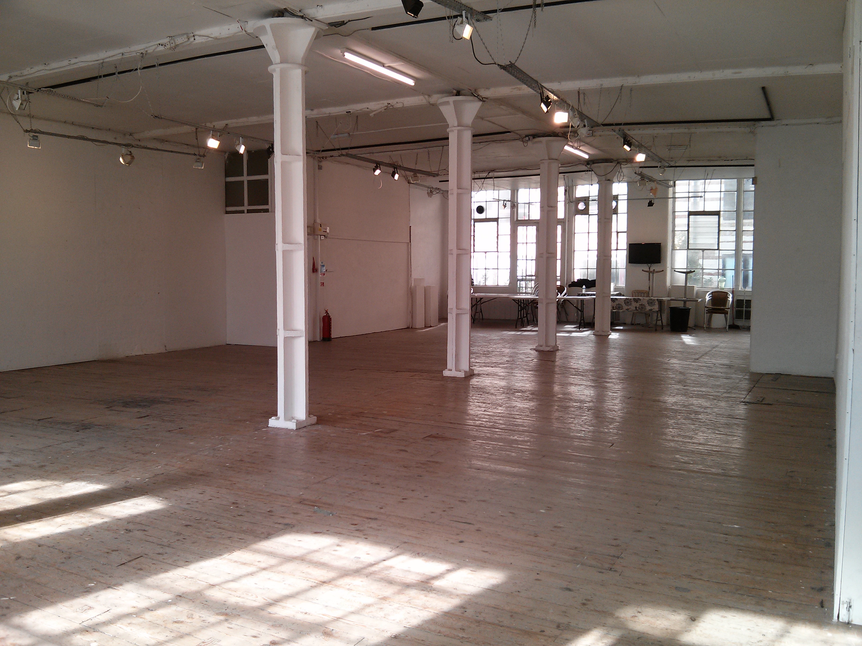 Spacious First Floor Gallery with polished wood floors for events and workshops.