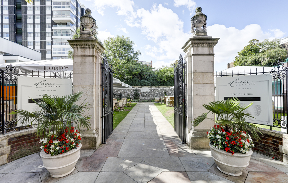 Harris Garden entrance at Lord's Cricket Ground, featuring elegant gates and vibrant flowers.