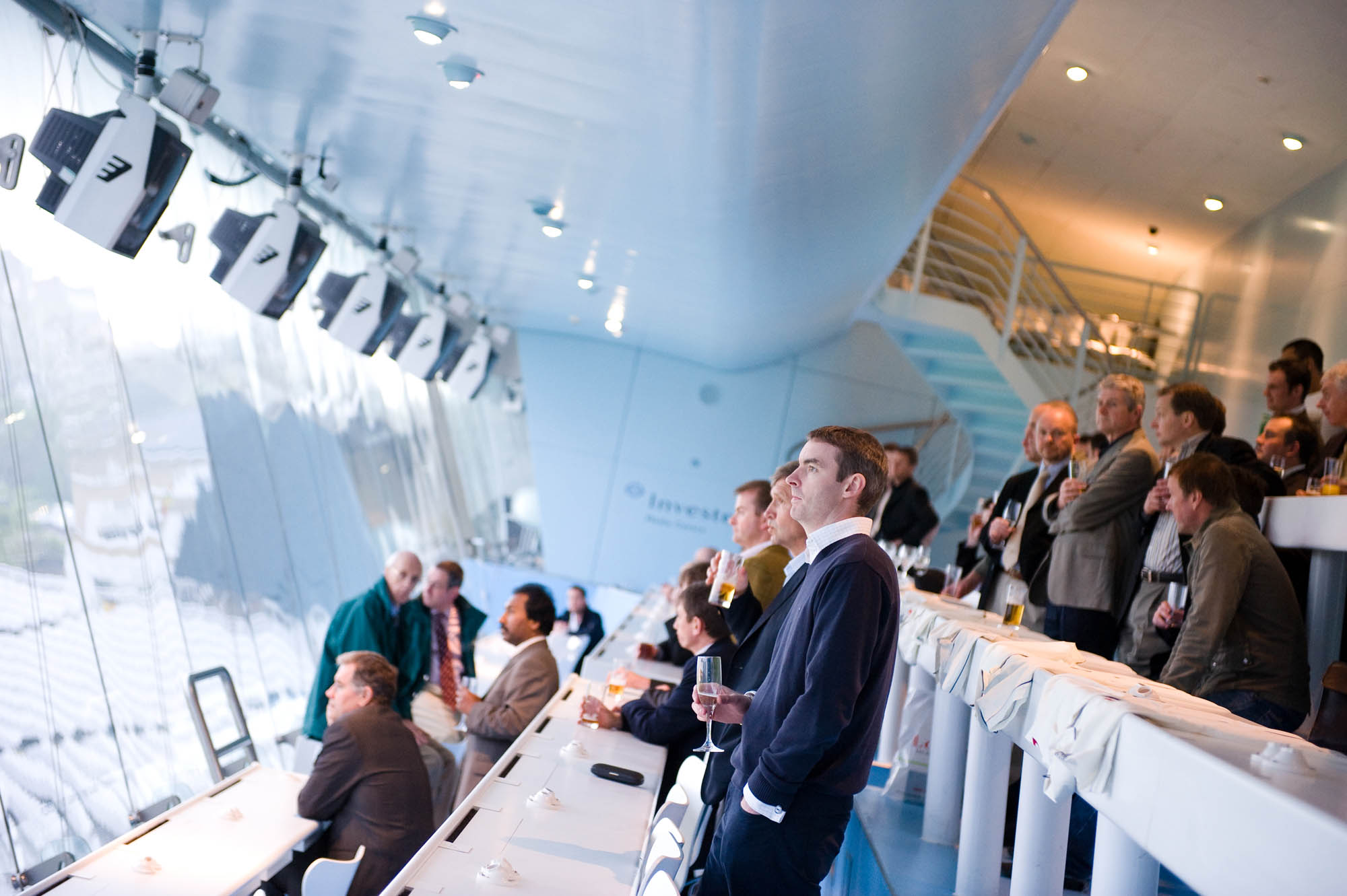 Networking event at J.P. Morgan Media Centre, modern bar with professionals enjoying drinks.