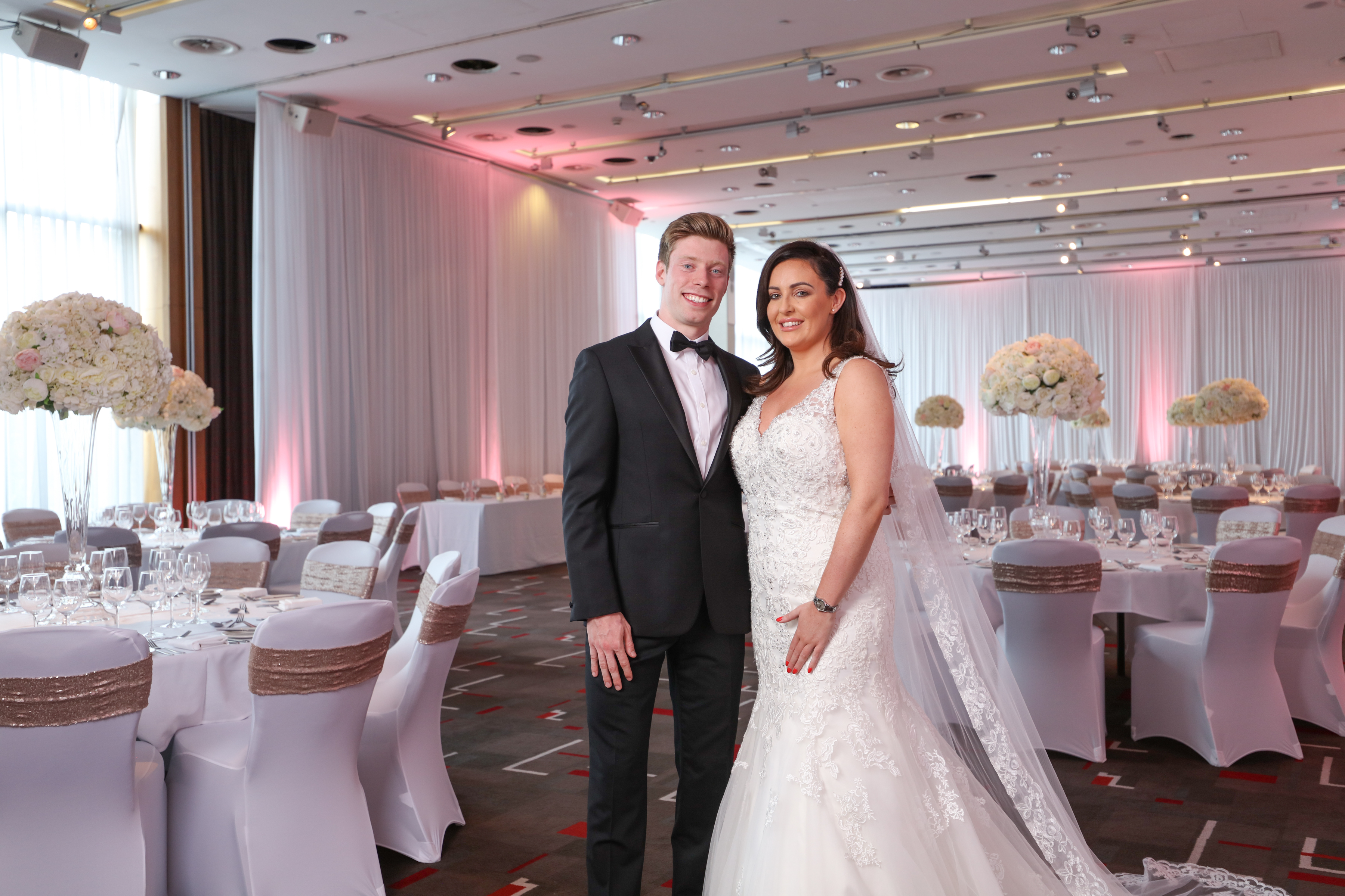 Elegant wedding reception in Grace Suite, Hilton Liverpool with floral decor and joyful couple.