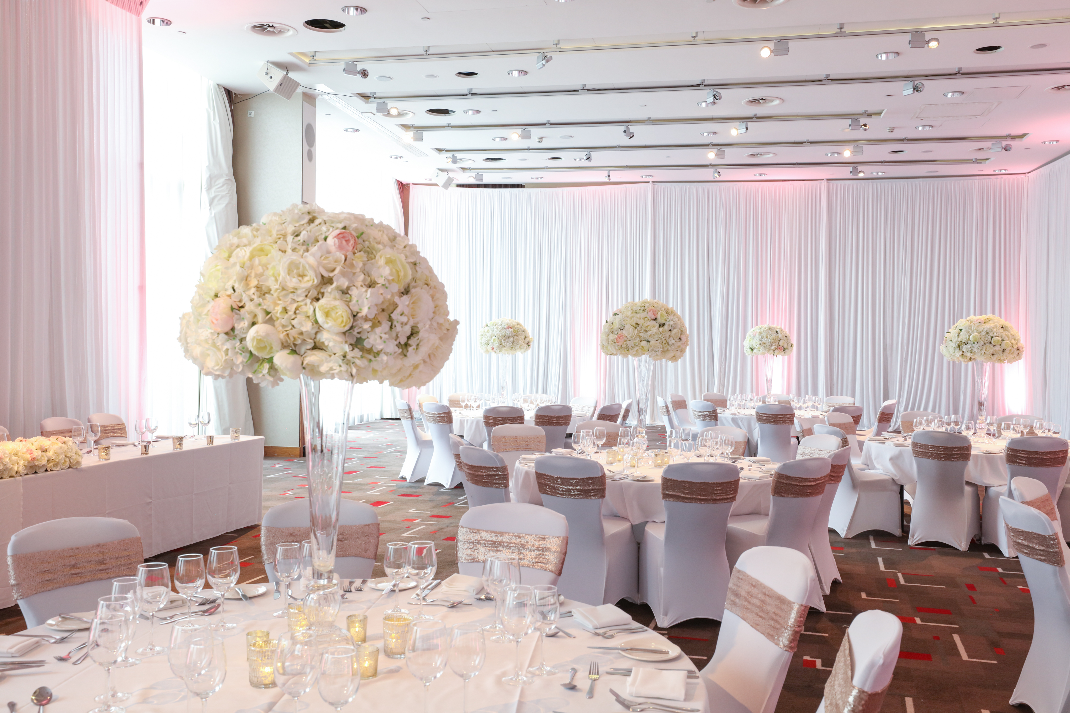 Grace Suite at Hilton Liverpool: elegant wedding venue with floral centerpieces and soft lighting.