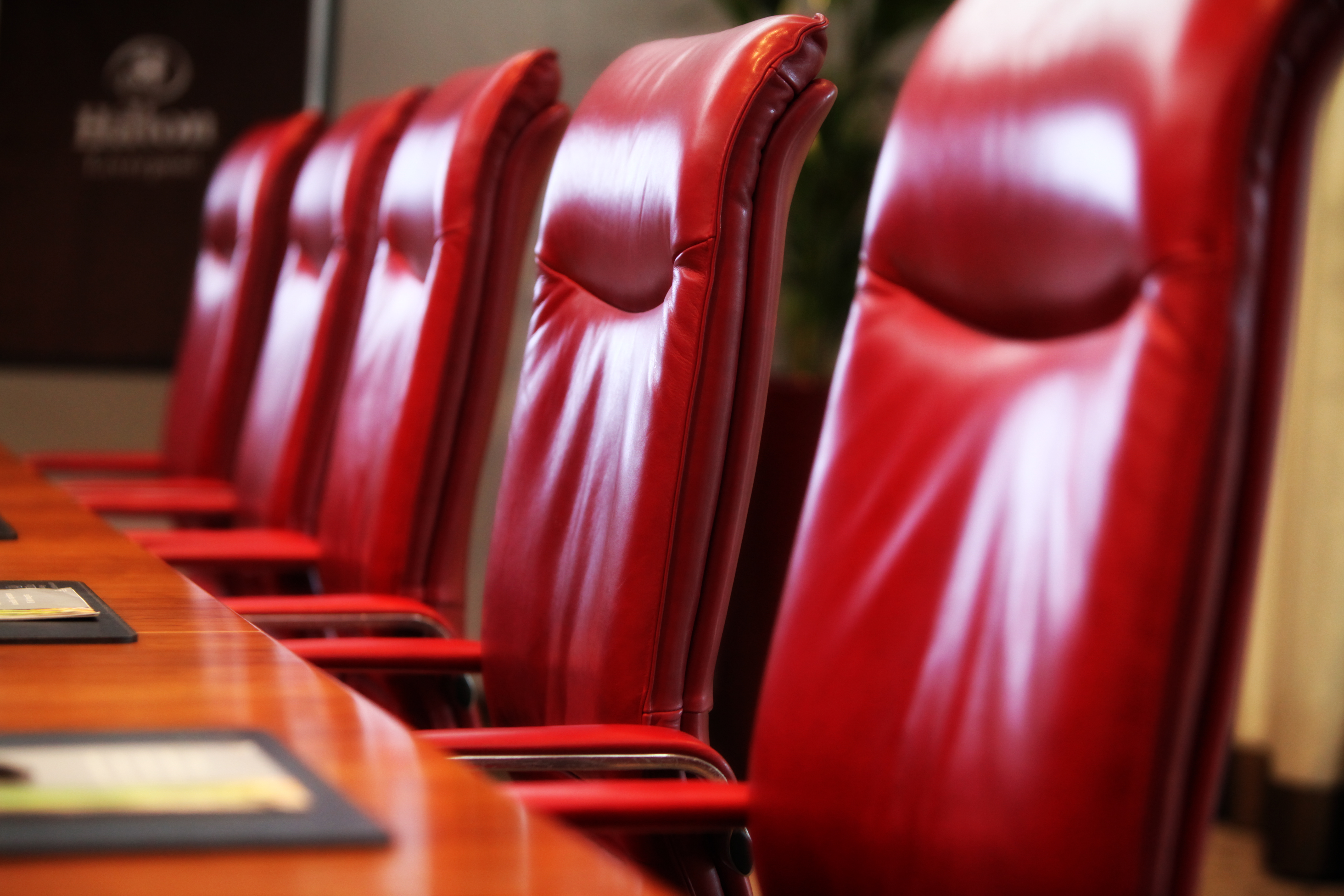 Boardroom with red leather chairs at Hilton Liverpool for corporate events.