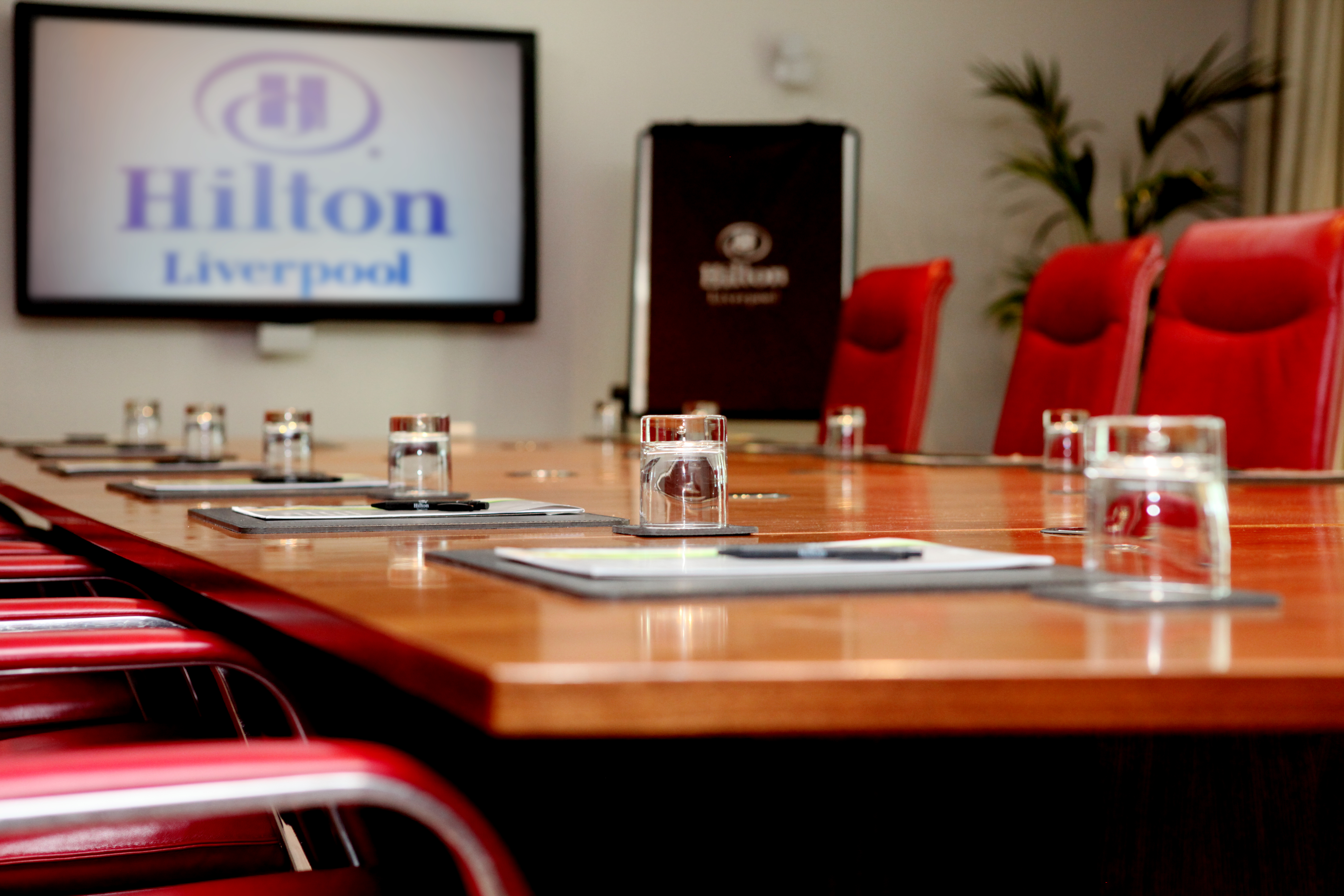 Boardroom at Hilton Liverpool with polished table, ideal for corporate meetings.