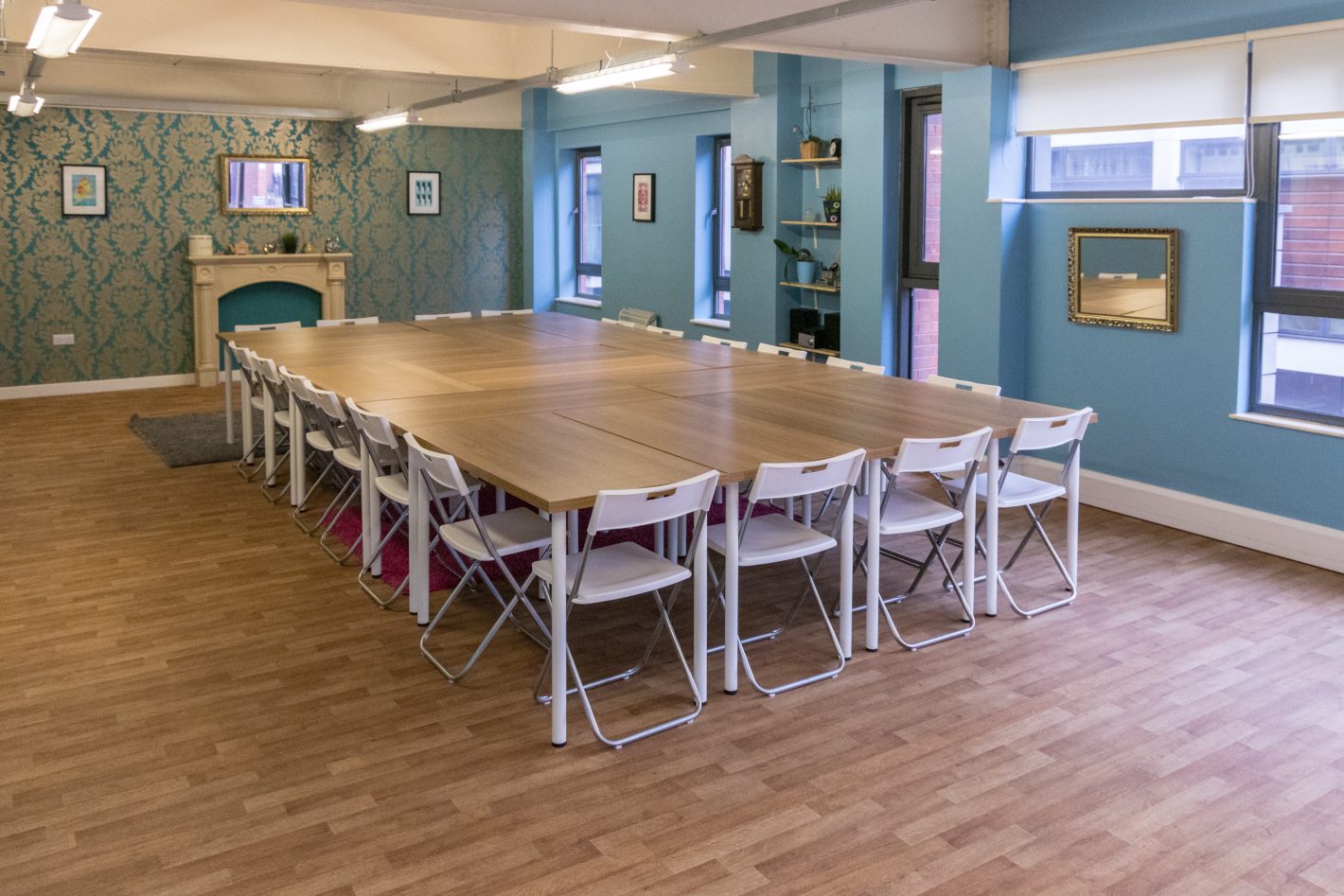 Spacious meeting room with wooden table, ideal for workshops and conferences.