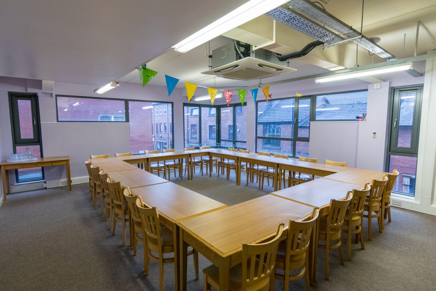 Collaboration space with U-shaped tables for workshops and brainstorming at Clockwork Edge St.