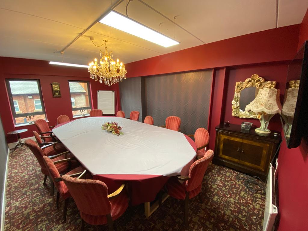 Elegant meeting room with oval table, perfect for intimate corporate gatherings.