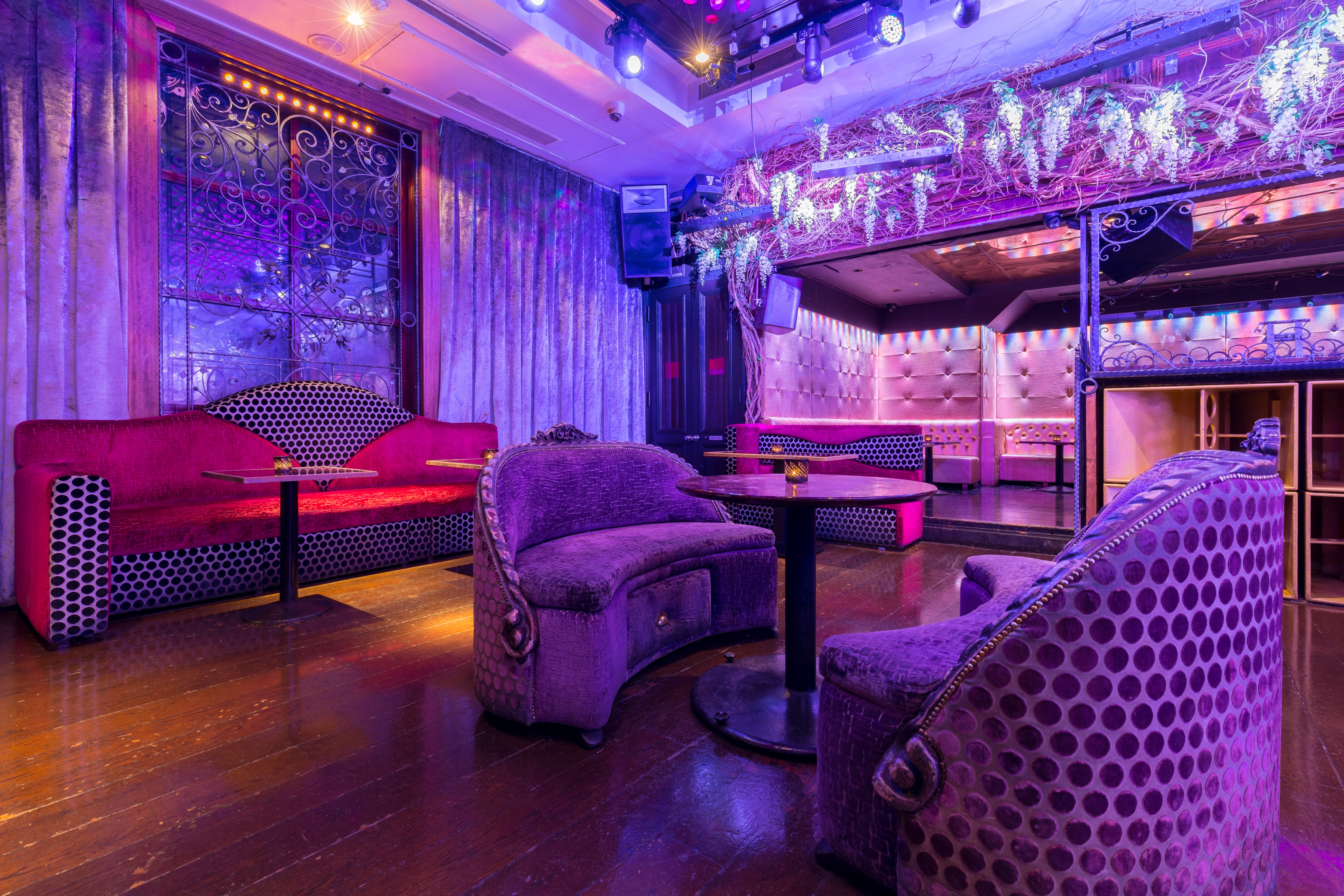 Stylish event space with plush seating and vibrant purple lighting for cocktail receptions.
