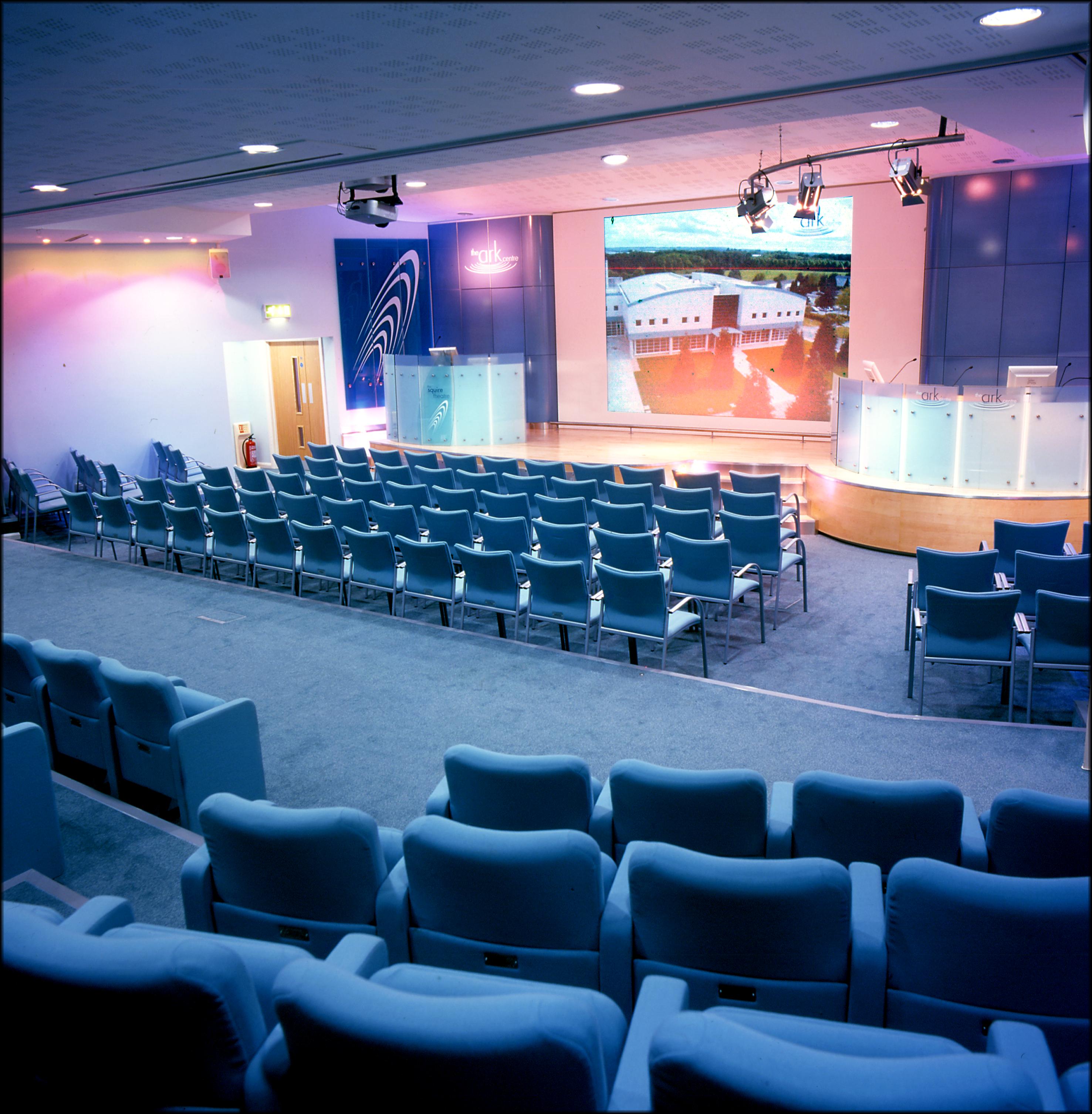 Modern conference room with tiered seating at Squire Theatre, ideal for corporate events.
