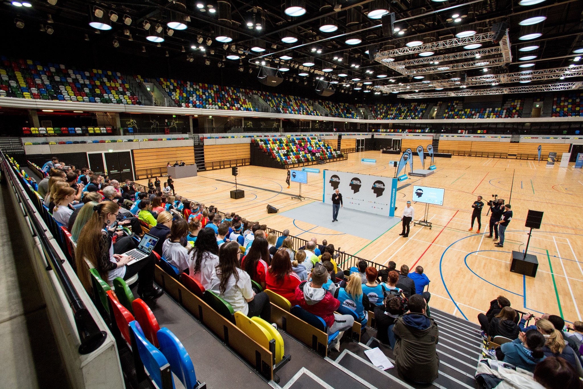 Main Arena at Copper Box, vibrant seating for a conference with media coverage.