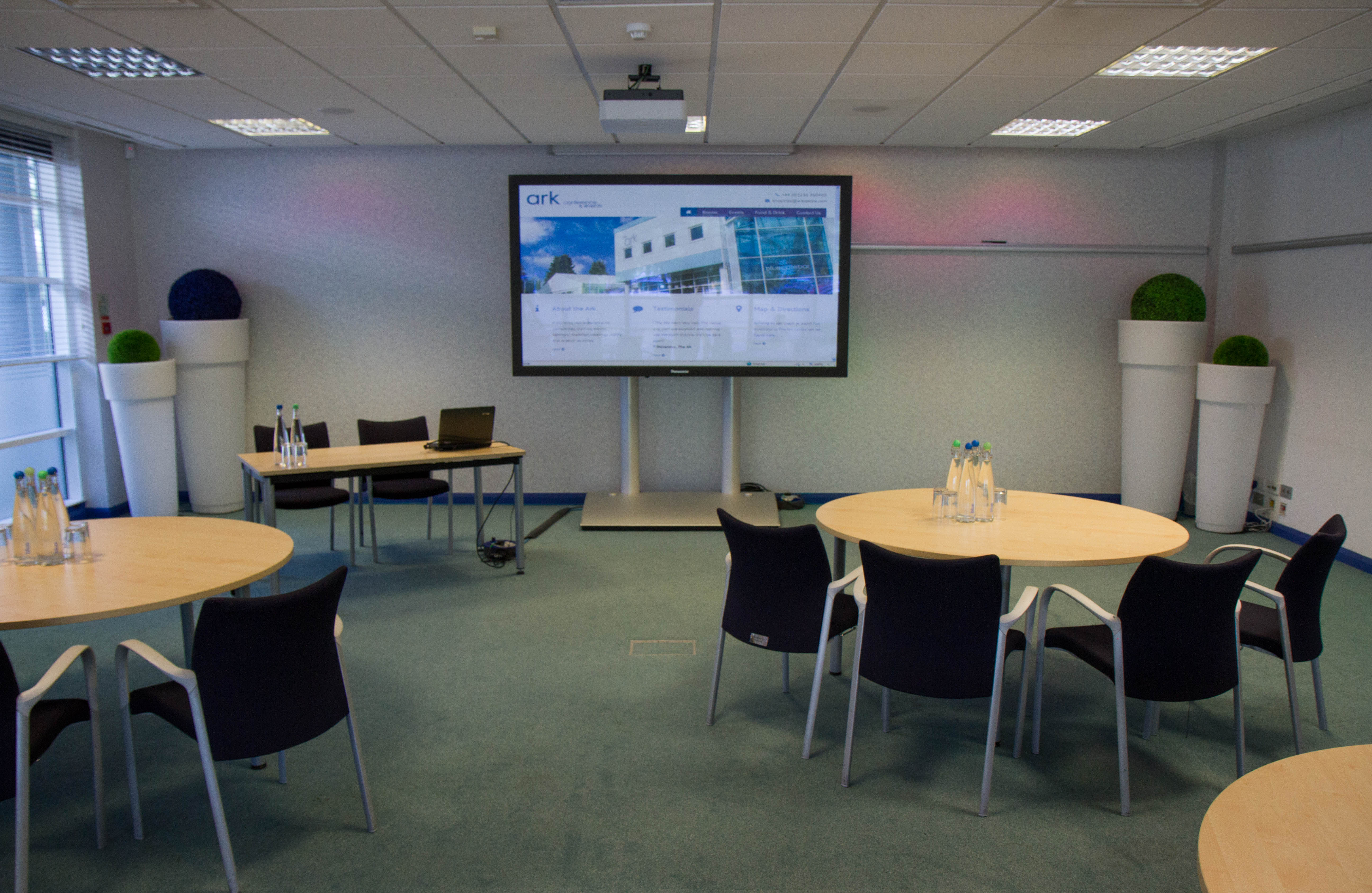 Caspian meeting room with round tables, ideal for workshops and corporate events.