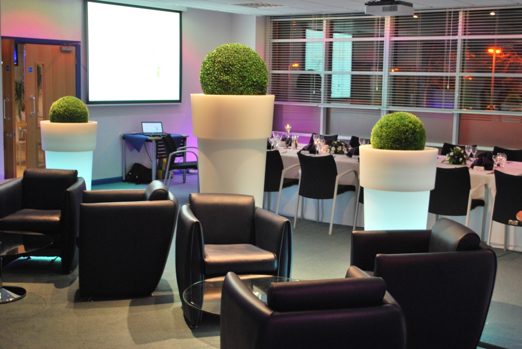 Modern event space with stylish seating and illuminated planters at The Ark Conference Centre.