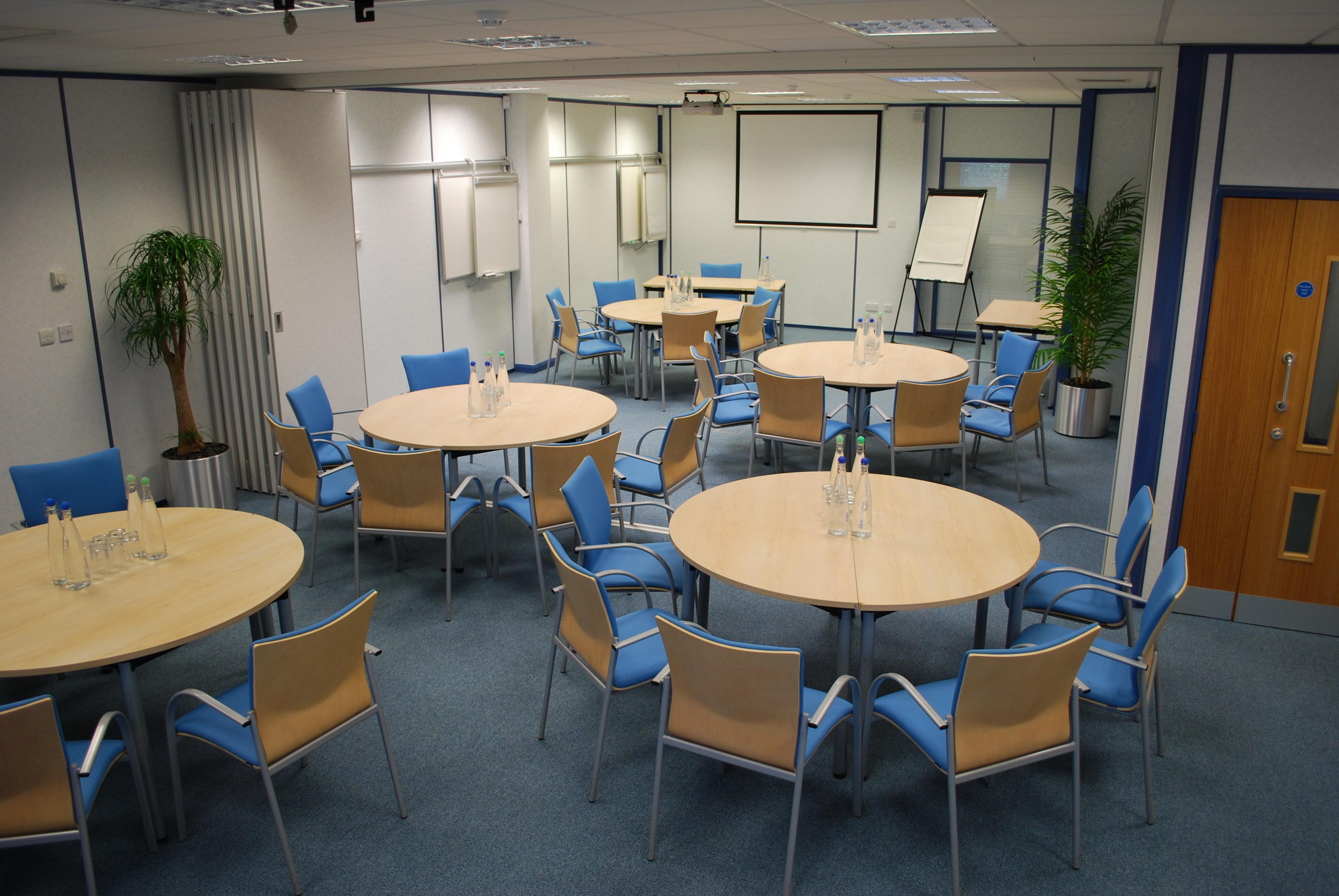 Meeting space with round tables and natural light for workshops at The Ark Conference Centre.