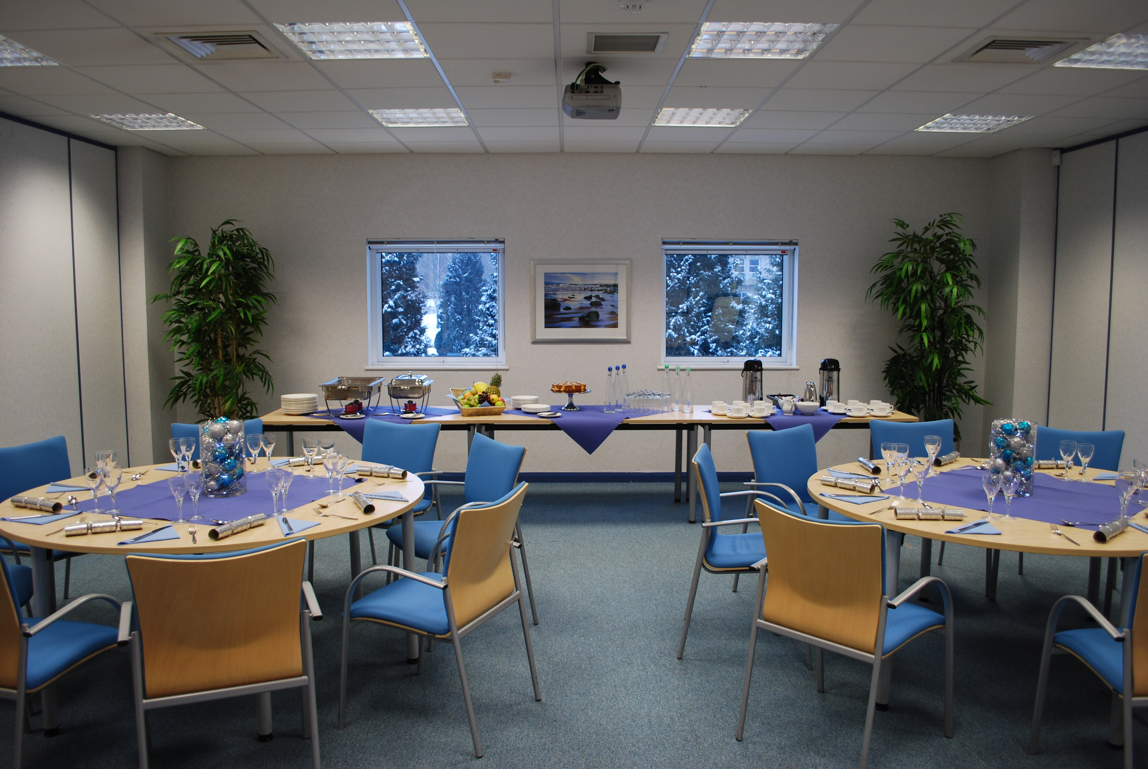 Lugano meeting room with purple tables, ideal for conferences and networking events.