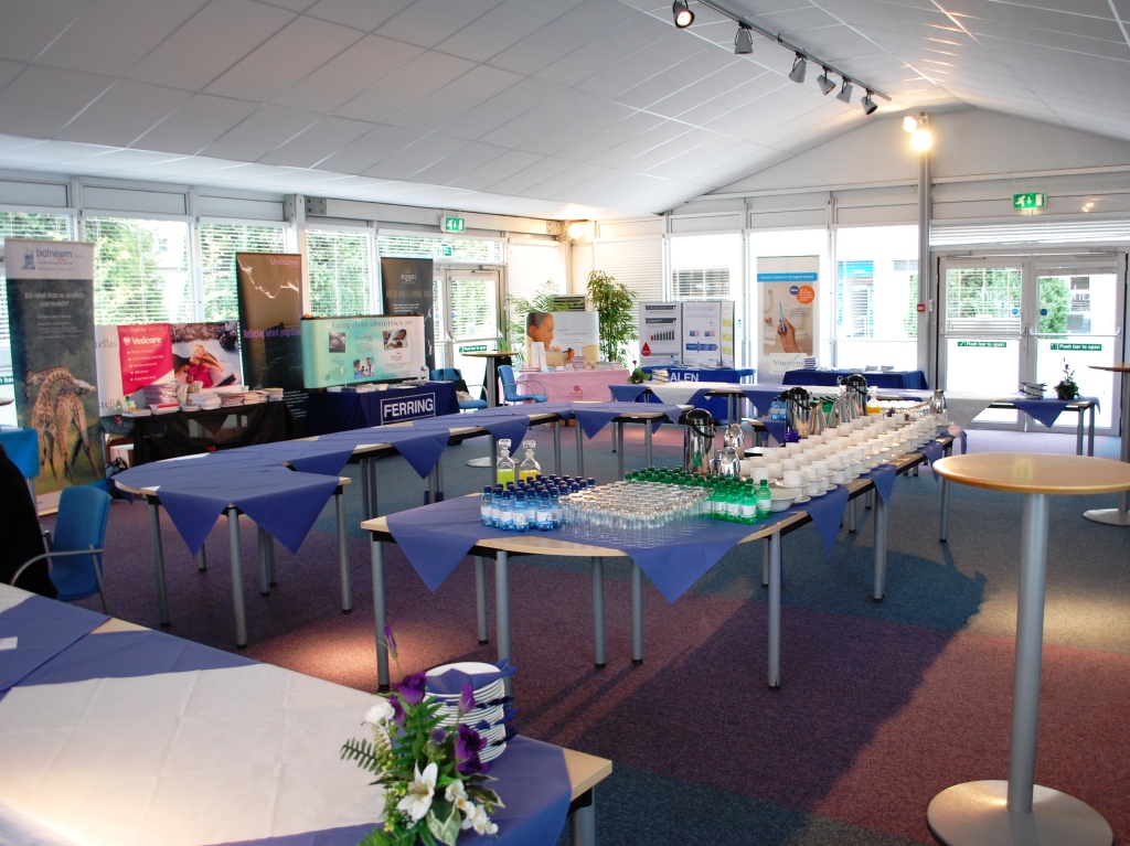 Event space at The Ark Conference Centre with blue-draped tables for meetings and exhibitions.