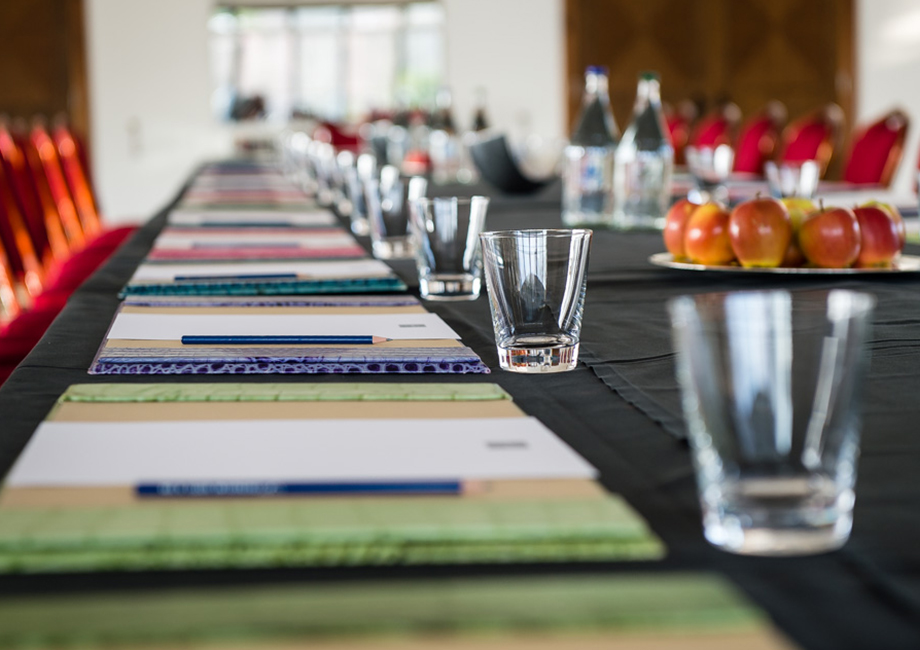 Meeting setup in Leverhulme Hotel Conservatory with red chairs and notepads for events.