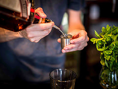 Bartender crafting a cocktail with fresh mint at The Arcade, Four Thieves event.