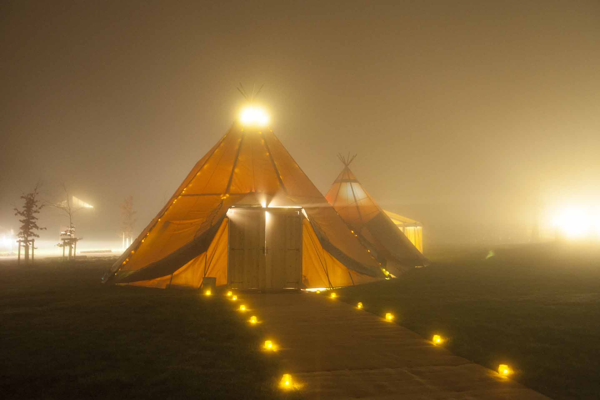 Illuminated Forest Tepee in misty Forest of Dean, ideal for enchanting outdoor events.