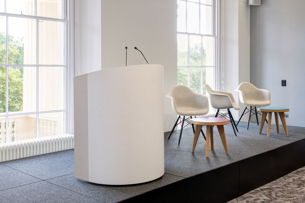 Modern stage setup in Prince Philip House for corporate panel discussions and presentations.