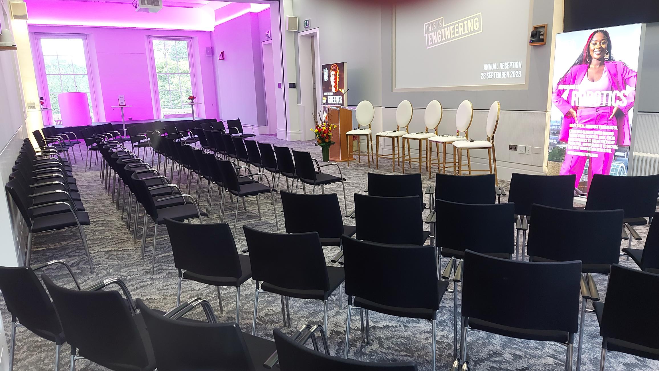 Event space in Prince Philip House with black chairs, ideal for panel discussions.