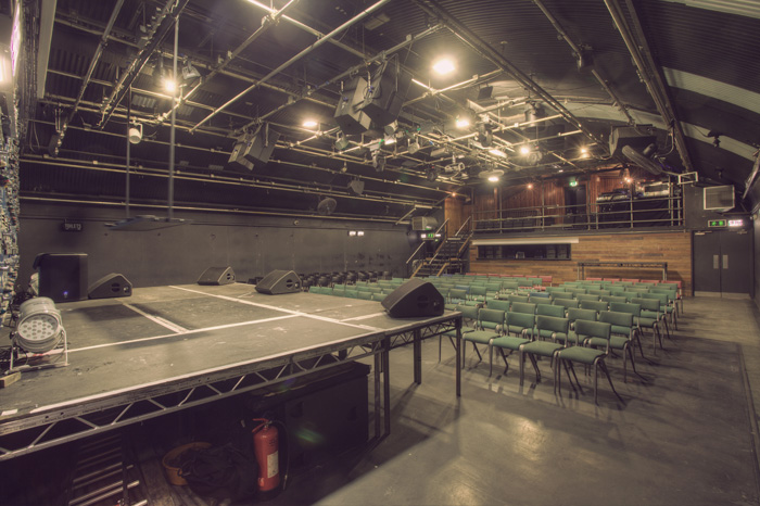 Versatile event space in Gorilla Manchester with raised stage and tiered seating for performances.