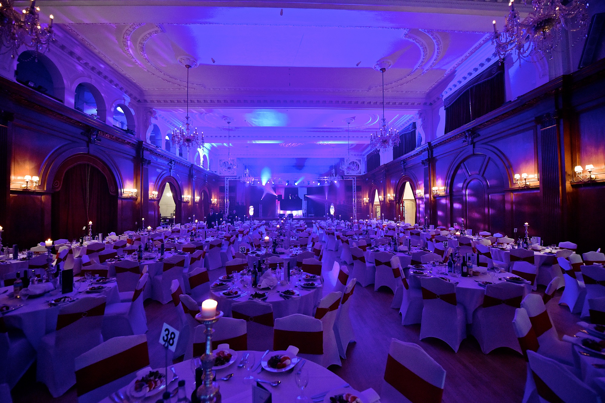 Elegant banquet hall with purple lighting, perfect for galas and corporate dinners.