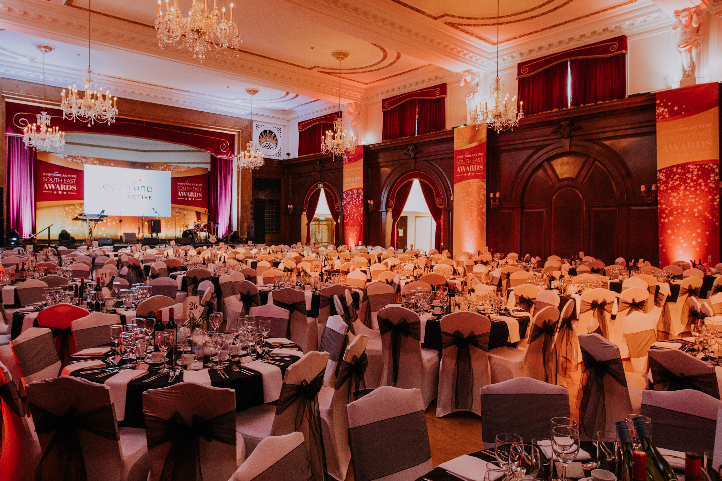 Elegant banquet hall with black and gold decor for corporate events and galas.