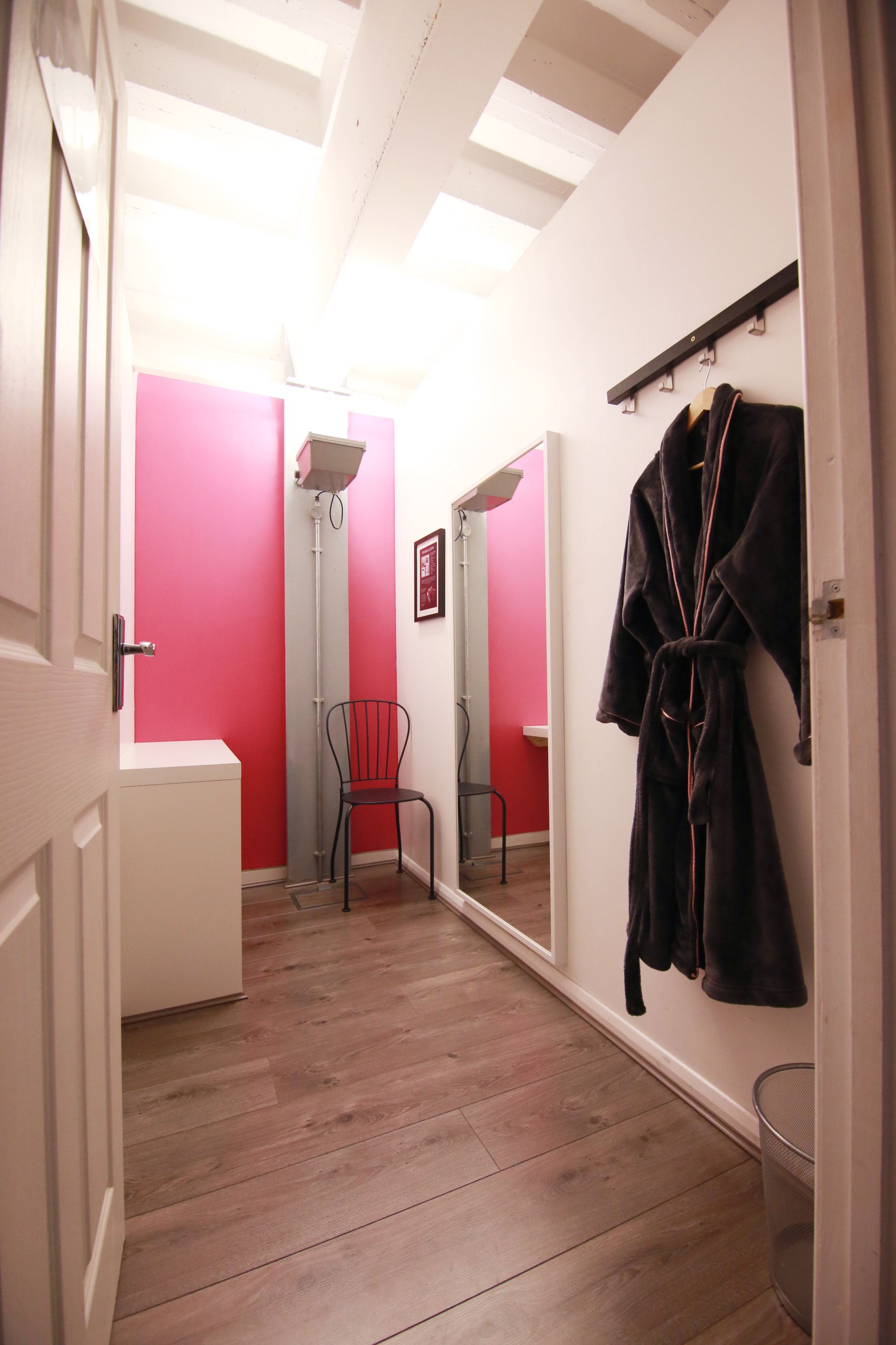 Cozy dressing area at Xposure Studios with pink wall, ideal for event professionals.