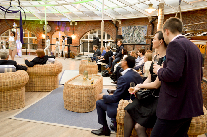 Vibrant Cabaret Club event in No Man's Fort with stylish wicker seating and lively atmosphere.