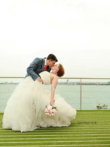 Romantic wedding couple in No Man's Fort with elegant water backdrop.