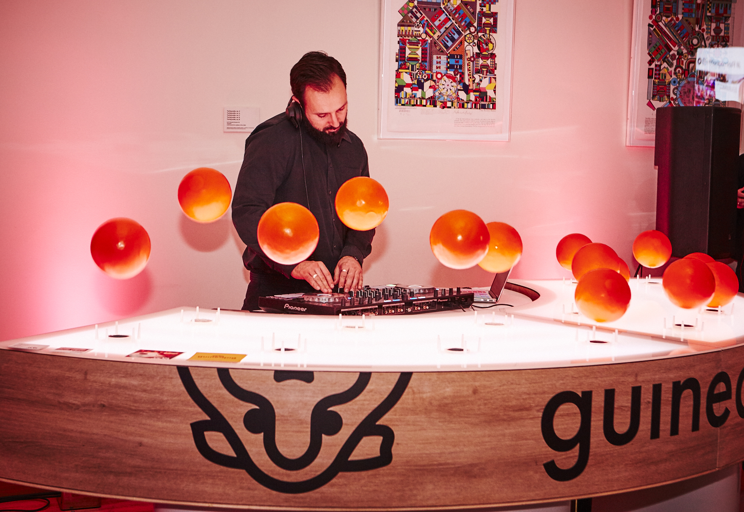Rolls Royce event setup with DJ and floating orange spheres for creative entertainment.