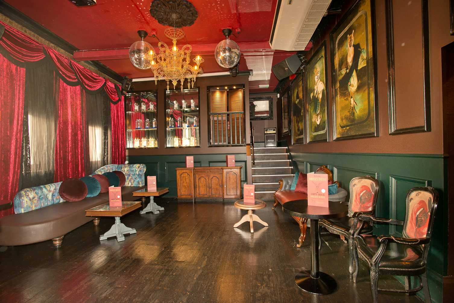 Stylish boudoir event space in Bar Soho with rich red drapery, perfect for gatherings.