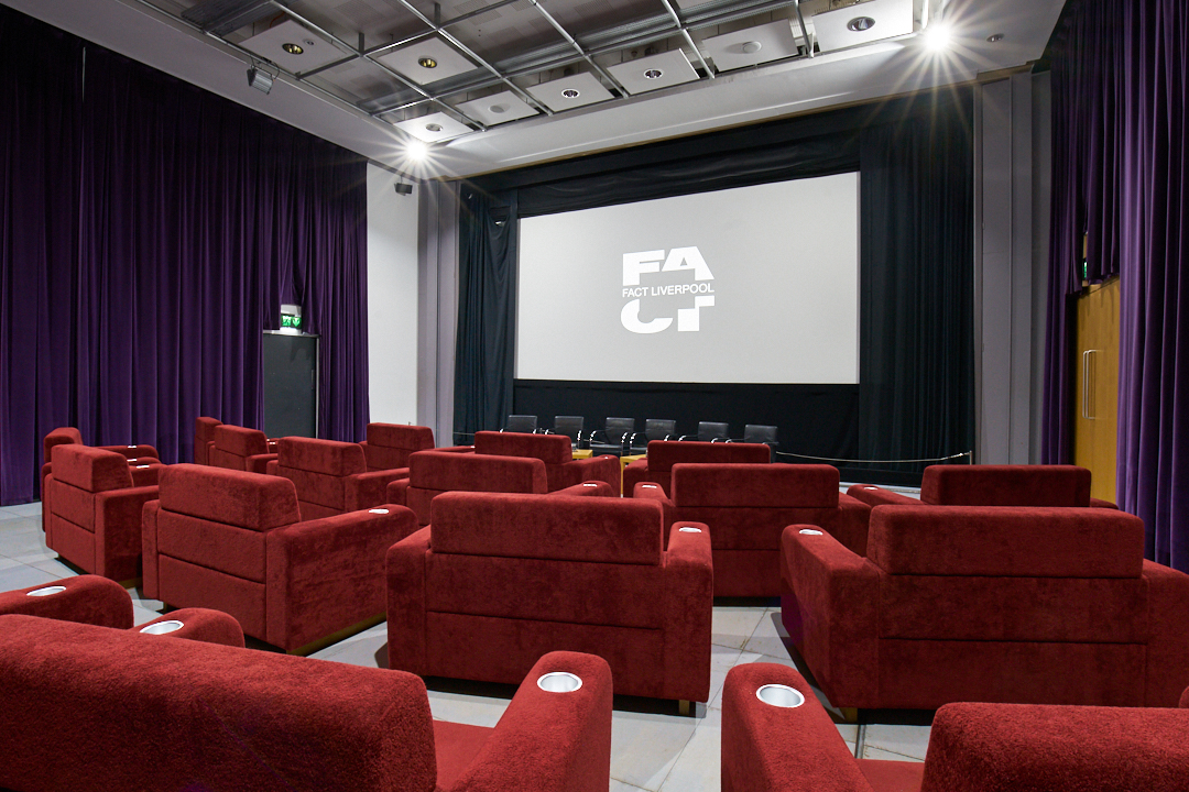 Modern auditorium at FACT Liverpool with plush red seating for events and screenings.