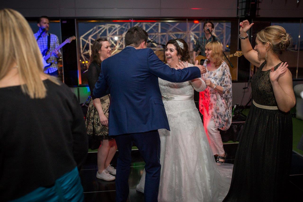 Lively wedding reception at Hotel Football with vibrant lighting and joyful dancing.