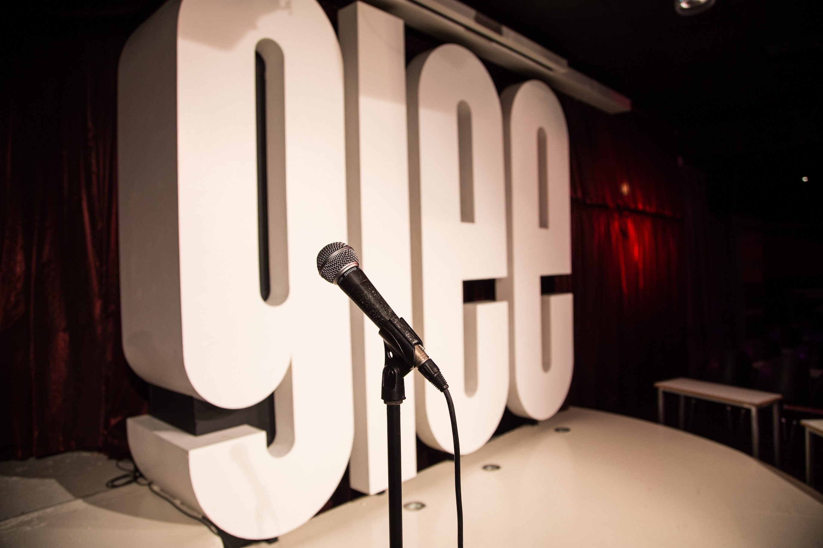 Vibrant Glee Club Birmingham stage with "glee" sign, perfect for comedy and talent events.