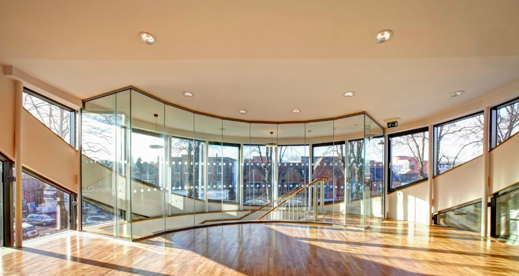 Modern event space at St Barnabas Church with glass walls and elegant staircase.