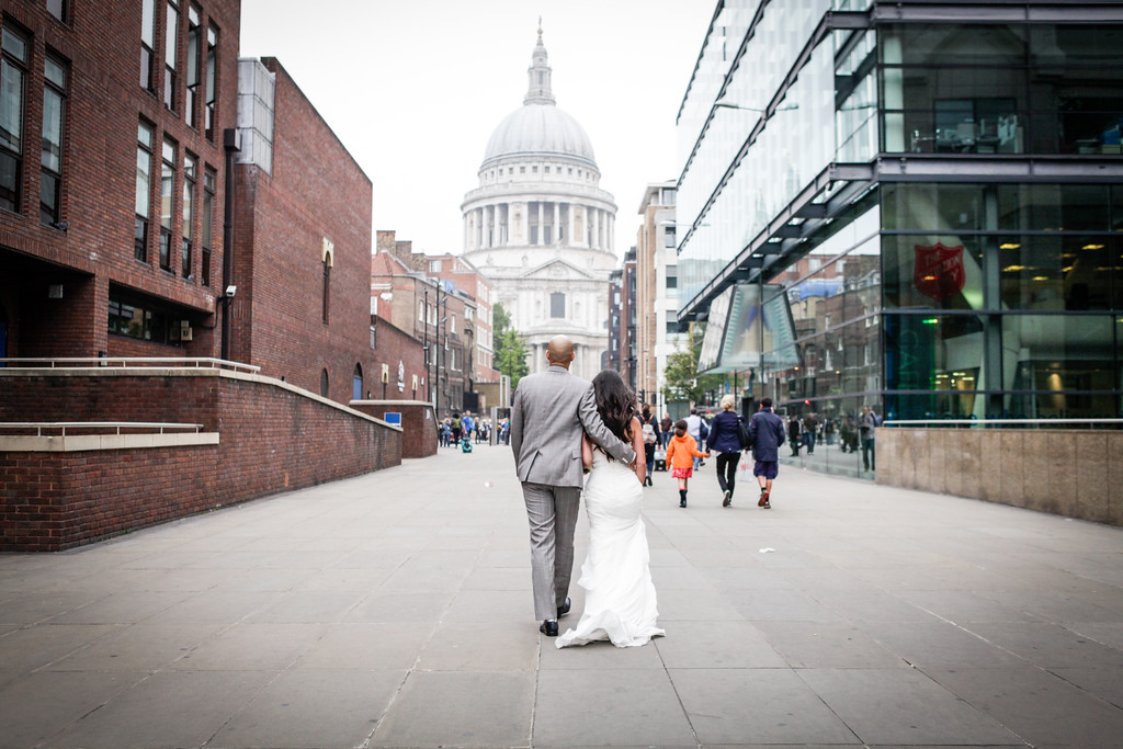 Couple walking hand in hand with St. Paul's Cathedral, perfect for urban wedding photography.
