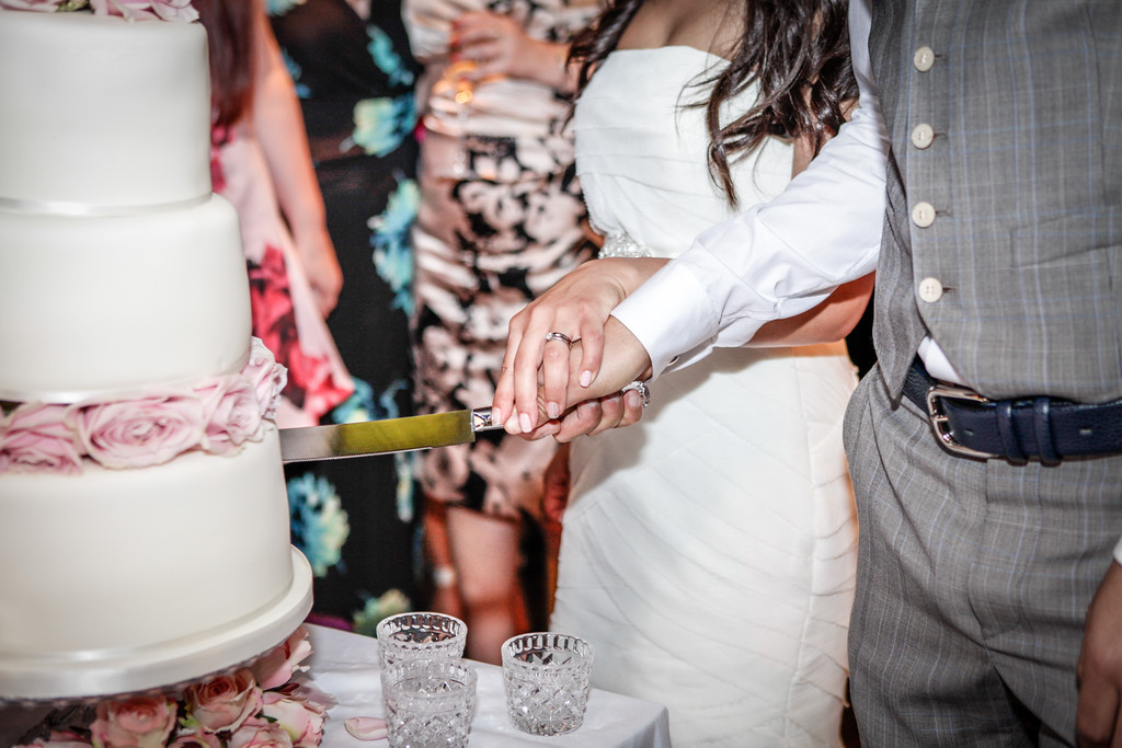 Couple cutting wedding cake at Patch St Paul's elegant venue, showcasing floral decor.