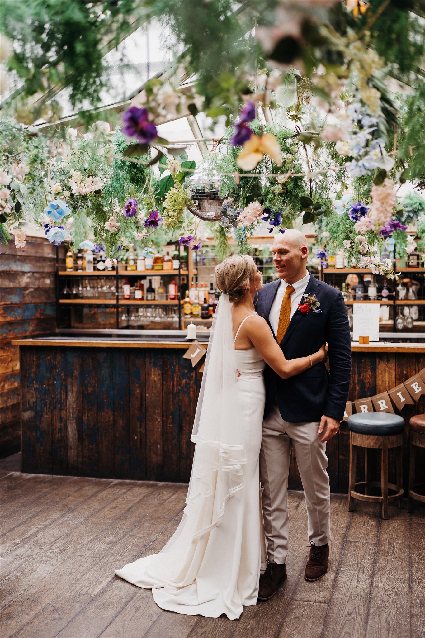 Wedding venue with lush floral decor and rustic bar, perfect for memorable celebrations.